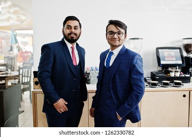 Two indian businessman in suits standing on cafe.
