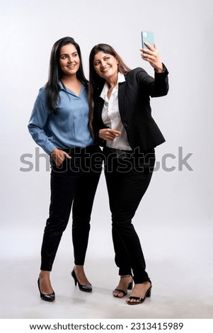 Two indian businesswoman or manager taking selfie on white background.
