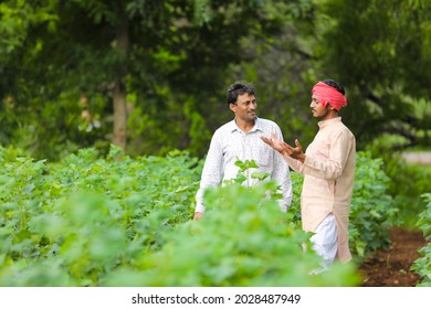 Two Indian farmers discuss at agriculture field.