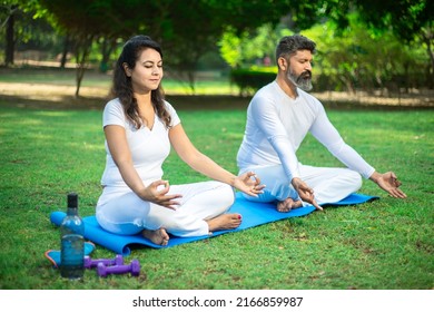 Two indian male and female person do yoga mediation exercise together in the summer  park outdoor. Healthy lifestyle, Sports and workout concept, - Powered by Shutterstock