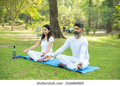 Two Indian Male And Female Person Do Yoga Mediation Exercise Together In The Park Outdoor. Healthy Lifestyle, Sports And Workout Concept,