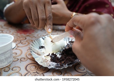 Two Indian People Sharing A Chocolate Brownie With Vanilla Ice Cream