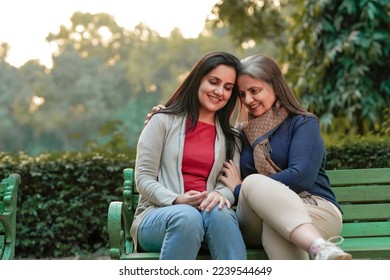 Two indian woman sitting at park in winter wear - Powered by Shutterstock