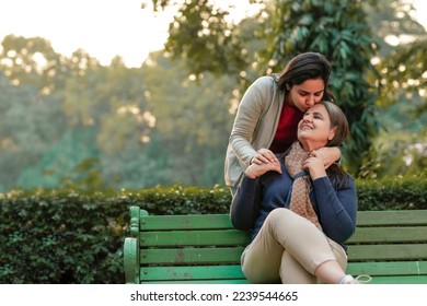 Two indian woman sitting at park in winter wear - Powered by Shutterstock