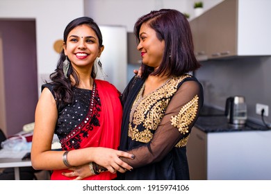 Two Indian Women With Bindi On The Forehead Hugging In Living Room