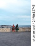 Two Indian women in traditional dress enjoy the panoramic view from Saint Remy Bastion in Cagliari, Sardinia