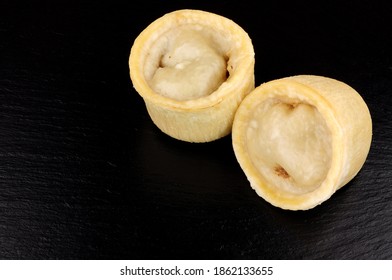 Two Individual Steamed Steak And Kidney Puddings In Suet Pastry Cases On A Slate Background