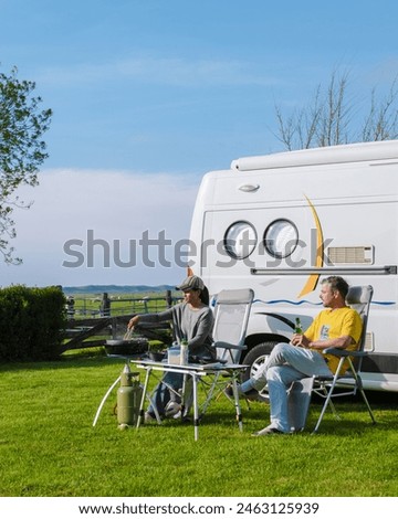 Two individuals are seated in front of their RV, enjoying the peaceful surroundings of a grassy field in Texel, Netherlands. camping at a farm in Texel Netherlands