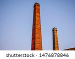 Two industrial brick chimneys photographed during blue hour at the Gazi area in Athens city.