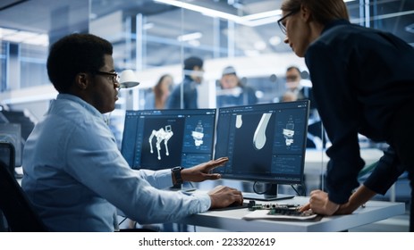 Two Industrial Engineers Discussing Work Projects, Talk and Use Desktop Computer in Robotics Startup Facility. Specialists and Professionals Researching and Developing High Tech Mobile Robot Dog. - Shutterstock ID 2233202619