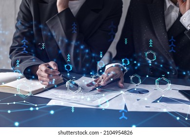 Two information technology specialist brainstorming on project to create a new approach to develop software to improve business service. Technological icons over the table with document.