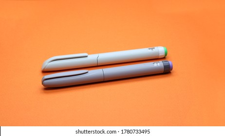 Two Insulin Pens, Injector Pen On An Orange Background