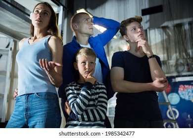 Two Interested Teen Boys With Their Parents Trying To Get Out Of Closed Space Of Escape Room Stylized Under Abandoned Nuclear Bunker, Contemplating Solving Conundrums..