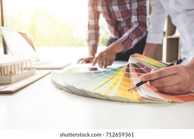 Two interior design or graphic designer at work on project of architecture drawing with work tools and color swatches, colour chart, color samples for selection, renovation and technology concept. - Powered by Shutterstock