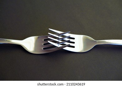 two interlocking silver forks in authentic gray colors