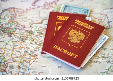 Two international passports of the Russian Federation with сash dollars and vaccination record cards on the world map. (Translation: Российская Федерация паспорт - Russian Federation passport) - Shutterstock ID 2138989723