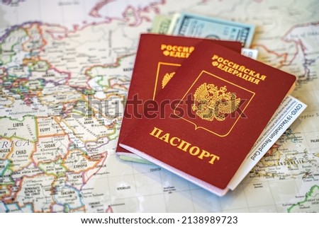 Two international passports of the Russian Federation with сash dollars and vaccination record cards on the world map. (Translation: Российская Федерация паспорт - Russian Federation passport)