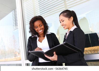 Two Interracial (african And Asian) Business Women Team At Office Building