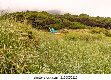 Two Isolated Empty Blue Chairs For Sitting And Relaxing While Looking Out On The Ocean Shore.