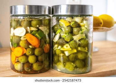 Two jars of traditional Andalusian-style pickled olives made at home, showcasing vibrant colors and fresh ingredients from Seville. Perfect representation of Mediterranean culinary heritage. - Powered by Shutterstock