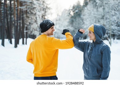 Two Joggers Greeting Each Other With A Elbow Bump Gesture During Winter Workout Outside