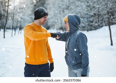 Two Joggers Greeting Each Other With A Fist Bump Gesture During Winter Workout Outside