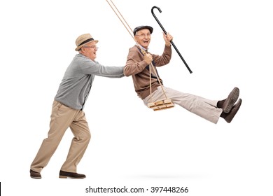 Two joyful senior gentlemen swinging on a swing and having fun isolated on white background