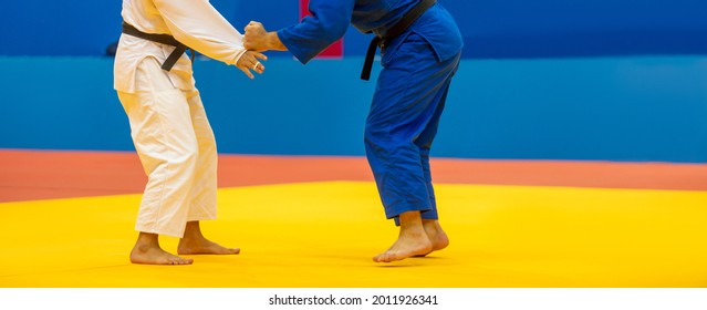 Two judo fighters in white and blue uniform. Horizontal sport poster, greeting cards, headers, website