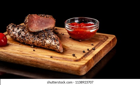 Two Juicy Beef Pepper Steak With A Air Fryer Medium Rare, With A Red Sharp Sauce On A Wooden Board, On A Black Background. Copy Space