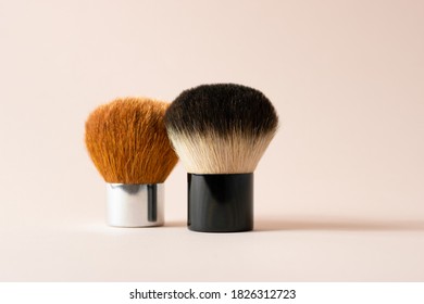 Two Kabuki Brushes Stand Next To Each Other On A Pink Background. Brushes For Powder And Blush.