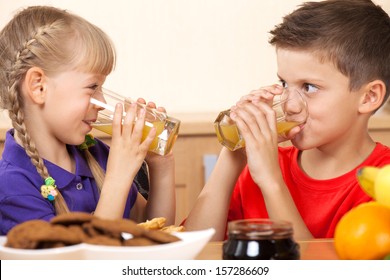 Two Kids Drink Orrange Juice While Looking On Each Other