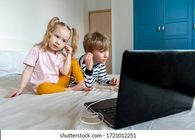 Two Kids Girl And Boy Using Laptop Amd Headphones At Home