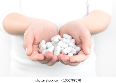 Two Kid's Hands Handful Of White Tablets, Drugs And Medicine Safety And Consumption Concept With Copy Space