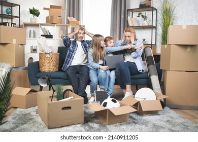 Two Kids Helping Parents To Calculate Boxes After Relocation. Shocked Parents Sitting On The Couch Touching Head With Hands, Preparing For Moving Day. Forgotten Box, Lose Things