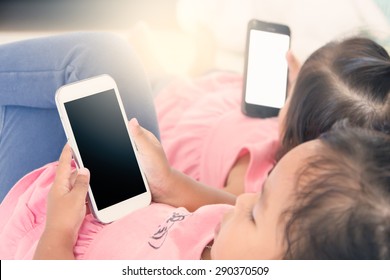 Two Kids Hold Smart Phone,tablet,cellphone For Playing And Education Together,soft Color Effect