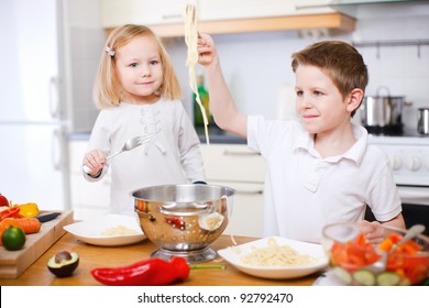 Two Kids At Kitchen Eating Spaghetti