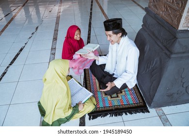 Two Kids Learning To Read Quran With Muslim Teacher Or Ustad