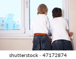 two kids looking at window