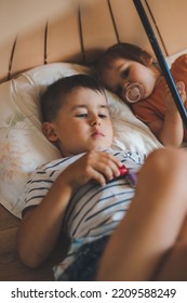 Two Kids Lying On The Floor With Pillows, Relaxing Under A Umbrella, Indoors. Happy Family. Fun Family.