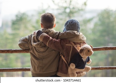 Two Kids On The Hiking, Stand And Look At The Horizon Surrounded By Warm Sunny Colors