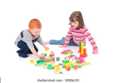 Two Kids Playing With Colorful Blocks. Isolated On White With Shadows.