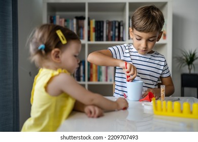 Two Kids Playing With Toys At Home One Boy Preschooler With His Little Sister Baby Girl Making Experiments Childhood Growing Up Concept