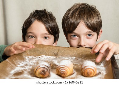 Two Kids Reaching For Freshly Baked Spiral Cookies On Tray