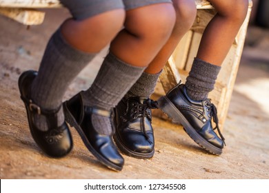 Two Kids Sitting On A Bench Waiting For The School Bus.