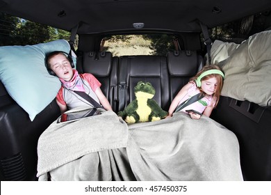 Two Kids Sleeping In The Back Of A Car