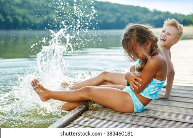 Two Kids Splashing Water With Their Feet In Summer