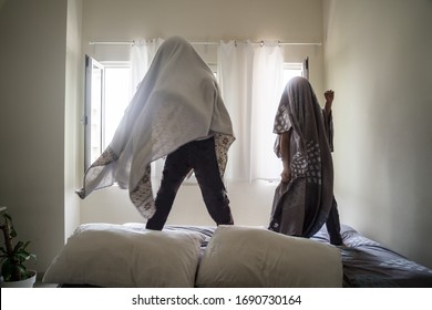 Two Kids Staying At Home Inside The Bedroom. Dancing, Laughing, Running And Jumping On The Bed. Windows Open - Photo, Motion Blur