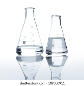 Two Laboratory Flasks With A Clear Liquid, Isolated