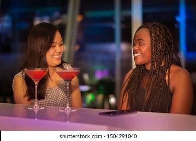 Two Ladies Of Different Nationality Enjoying The Night In A Bar.