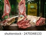 Two lamb carcasses and a beef rib hang in a Seville butcher shop, showcasing the premium quality of the meat.